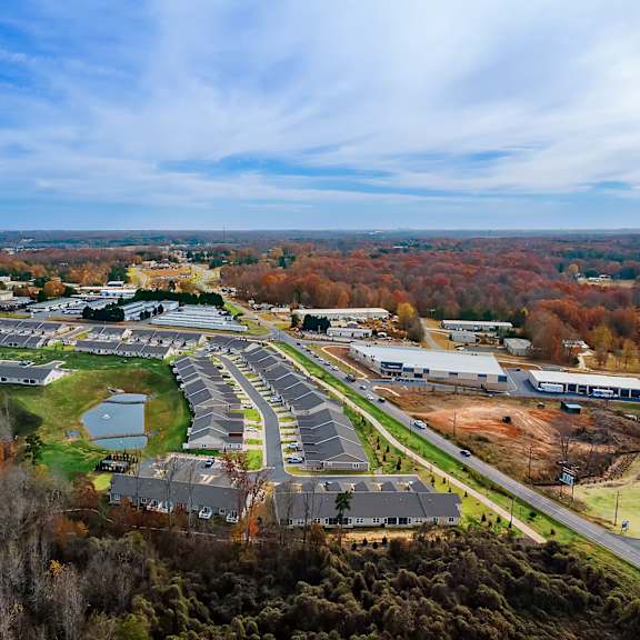 a large, open parking lot is surrounded by buildings and trees.