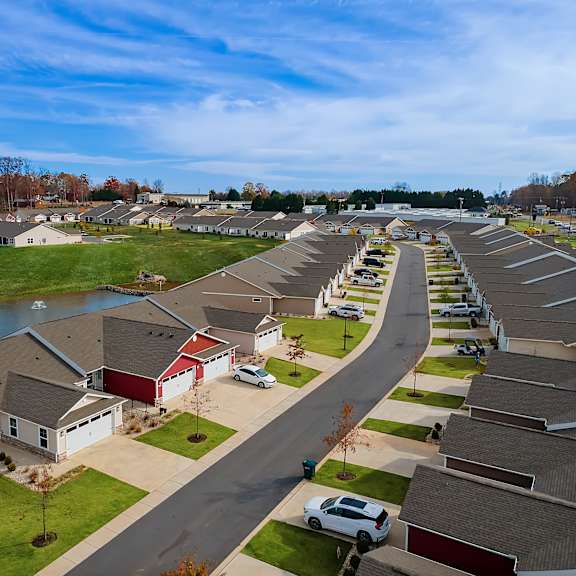 a suburban neighborhood with houses and a pond.