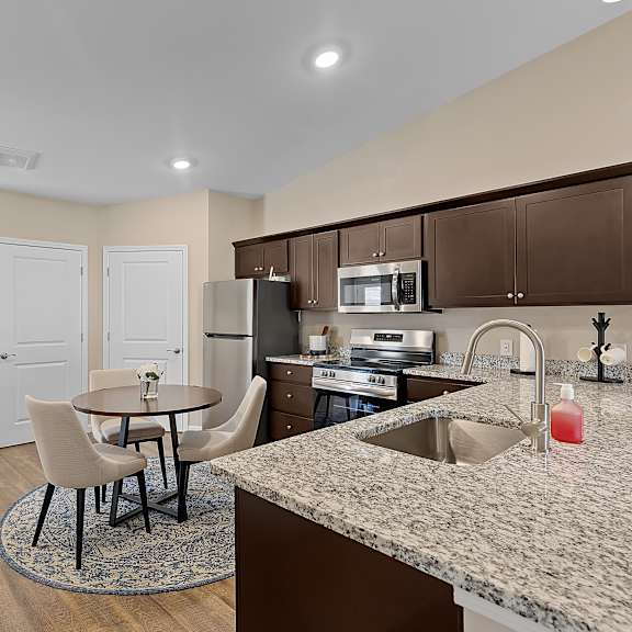 a kitchen with a table and chairs in the middle of the room.