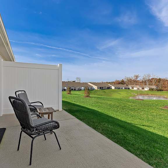 a chair is on a patio with a table and a mat.