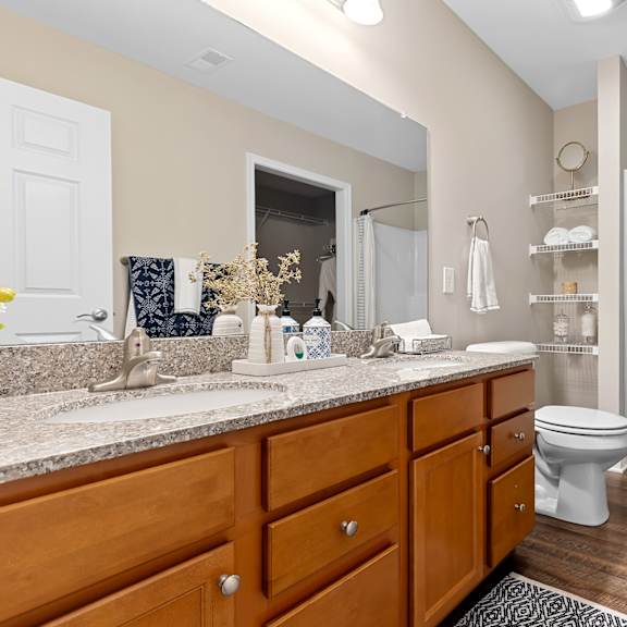 a bathroom with a toilet, sink, and shower.