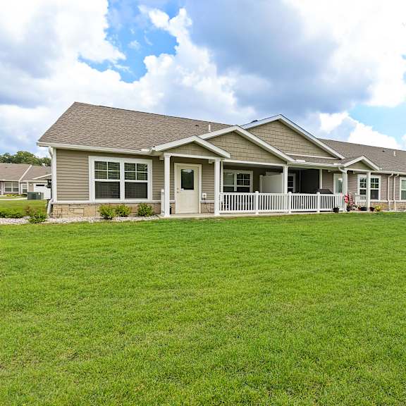 a row of houses with green lawns in front.