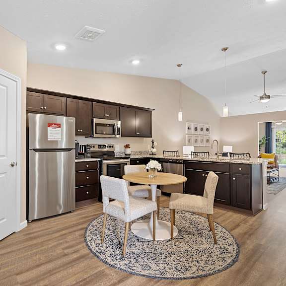 a modern kitchen with a dining table and chairs in the middle.