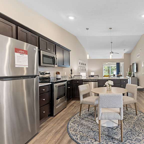 a kitchen with a dining table and chairs in the middle of the room.