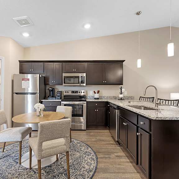 a modern kitchen with a dining table and chairs.