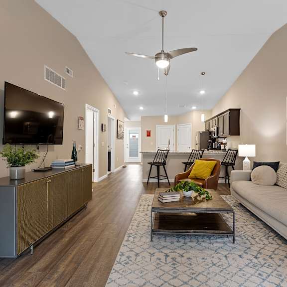 a living room with a white couch, a coffee table, and a television.
