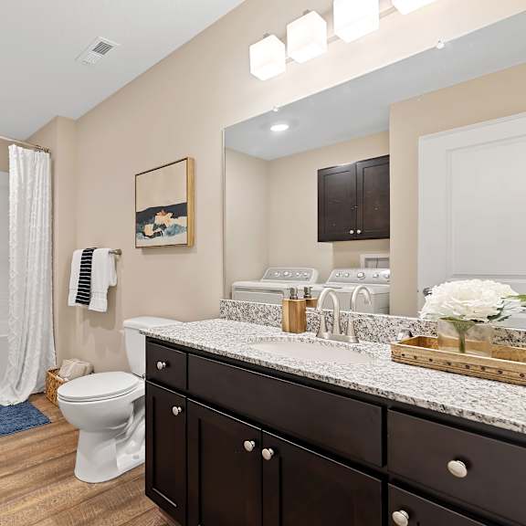a bathroom with a white tub, a toilet, and a sink.
