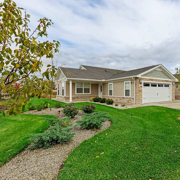 a house with a grey roof and a white garage door.