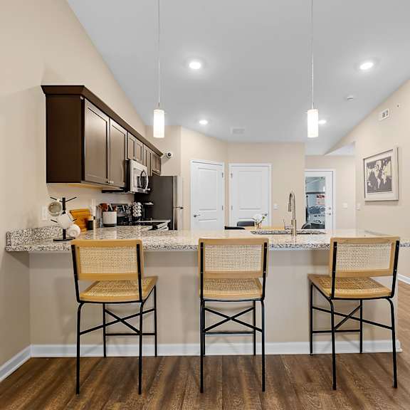 a kitchen with a bar area and two chairs.