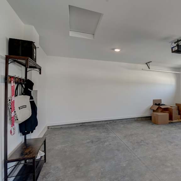 a spacious garage with a white wall and a grey floor.