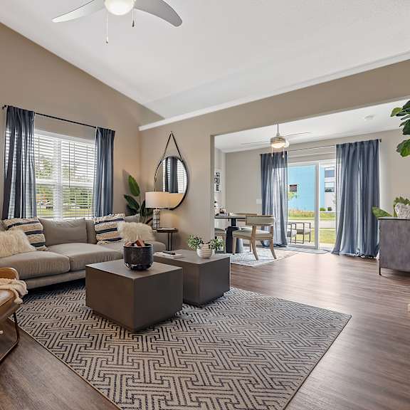 a living room with a brown leather chair and a grey sofa.