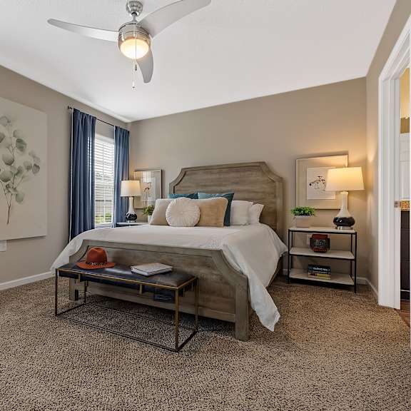 a bedroom with a bed, nightstands, and a ceiling fan.