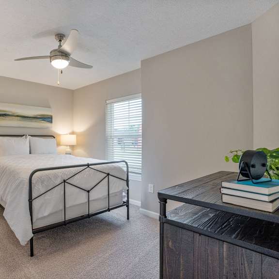 a bedroom with a bed, nightstands, and a ceiling fan.