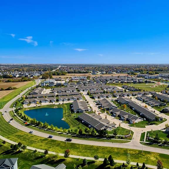 a bird's eye view of a residential area with houses and a lake.