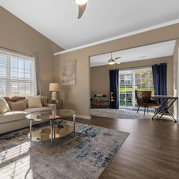 a living room with a white couch, a coffee table, and a rug.
