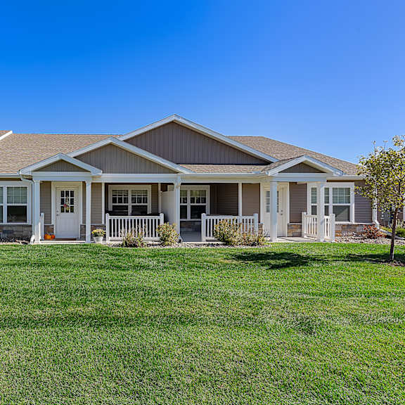a house with a brown roof and white fences.
