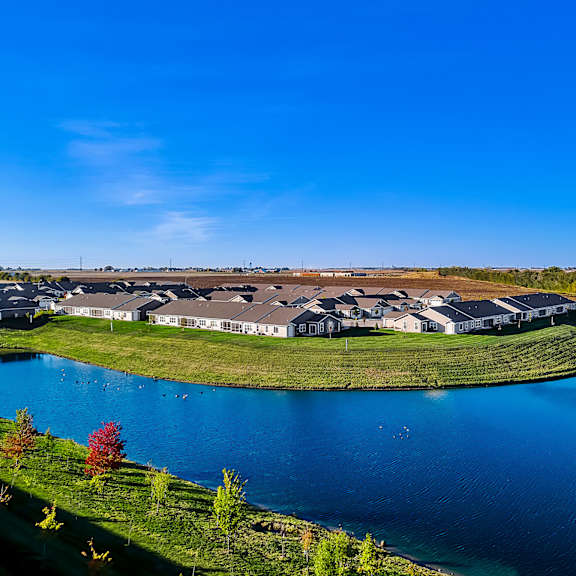 a large building complex is surrounded by a lake.