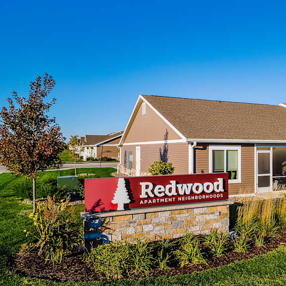 a sign for redwood apartment homes is in front of a building.