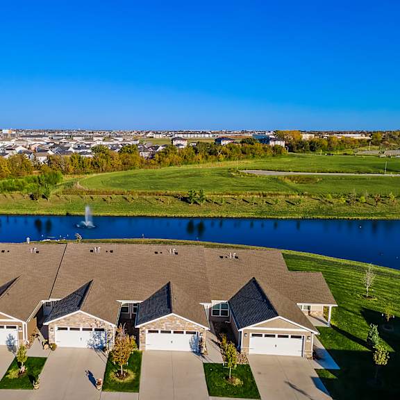 a row of houses with a pond in the foreground.