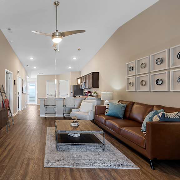 a living room with a brown leather couch and a wooden entertainment center.