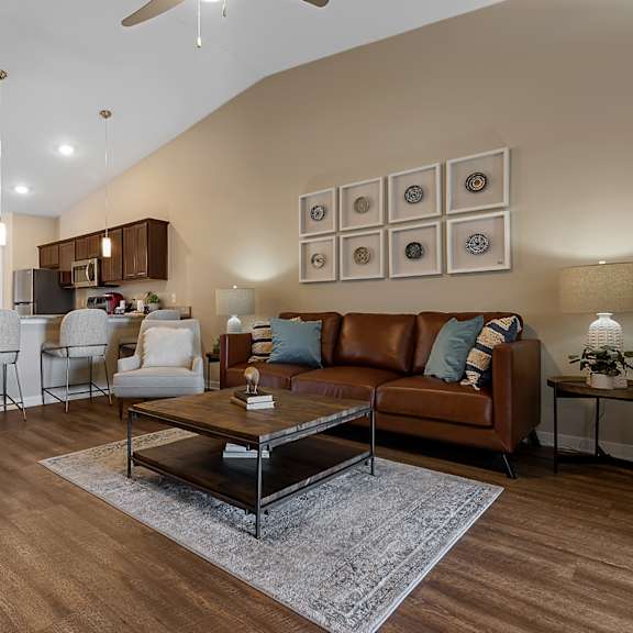 a living room with a brown leather couch and a coffee table.