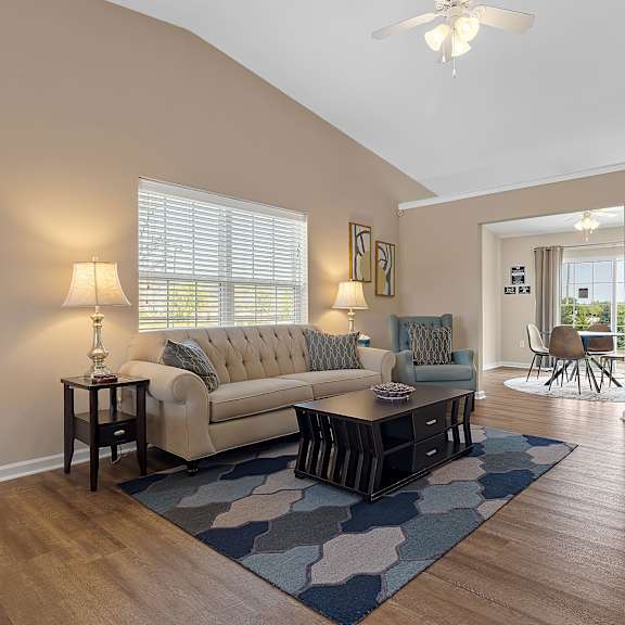 a living room with a couch, a table, and a rug.
