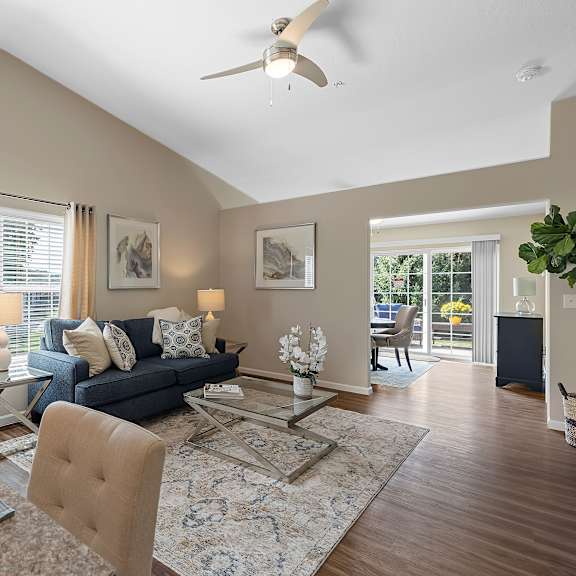a dining room with a table set for two and a couch in the background.