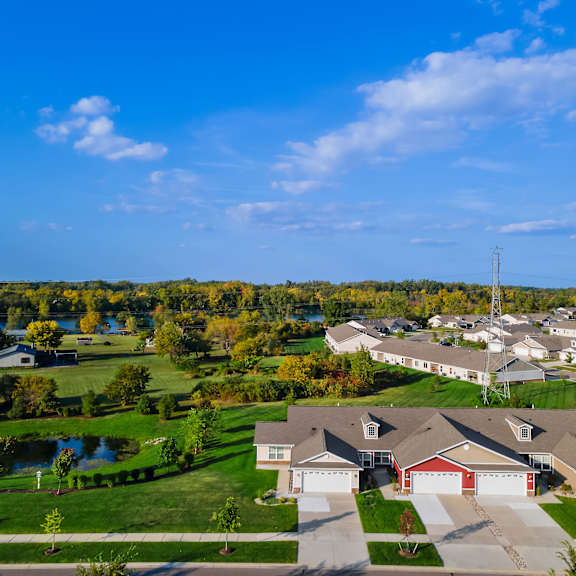 a suburban neighborhood with houses and a pond.