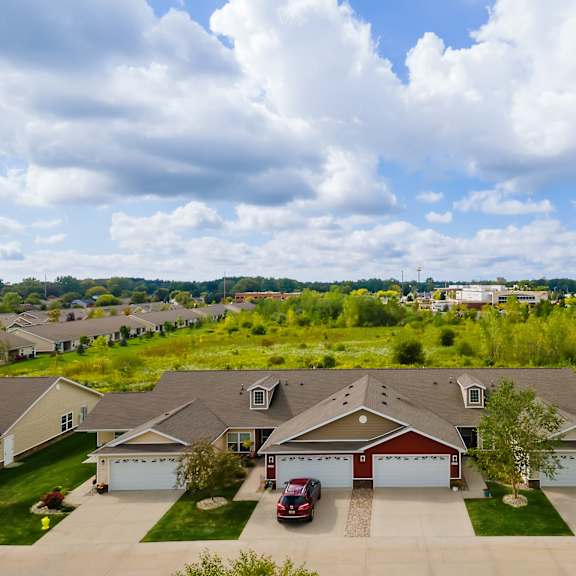 a red car is parked in the driveway of a house.