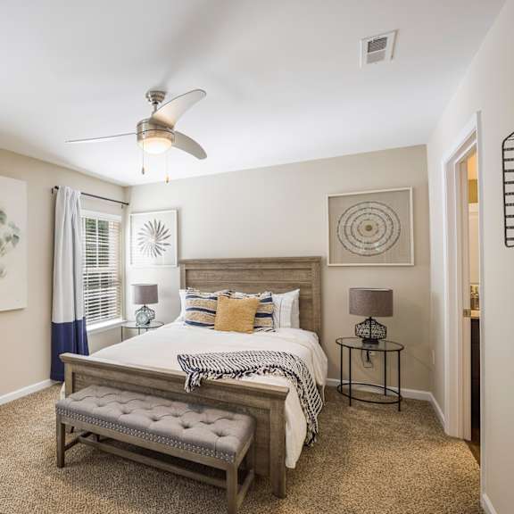 a bedroom with a large bed and a ceiling fan