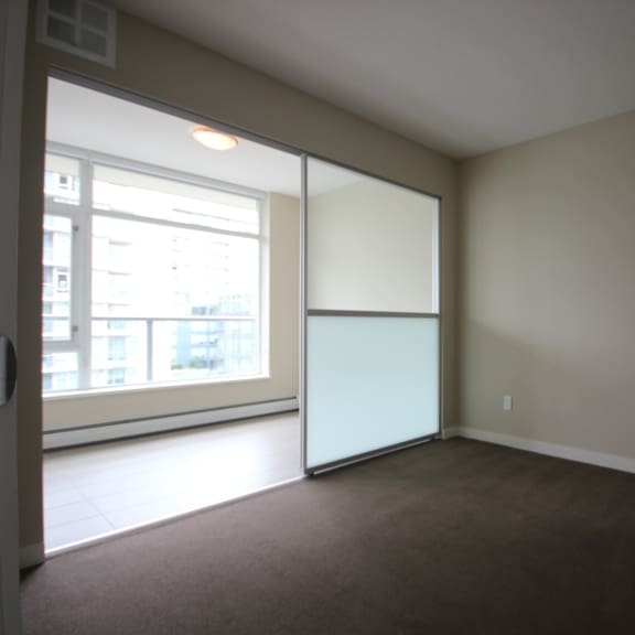 an empty room with a large window and a sliding glass door