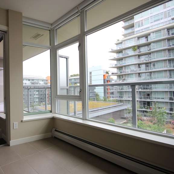 an empty room with large windows and a balcony