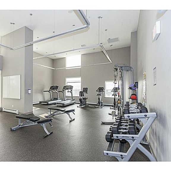 a large fitness room with treadmills and other exercise equipment