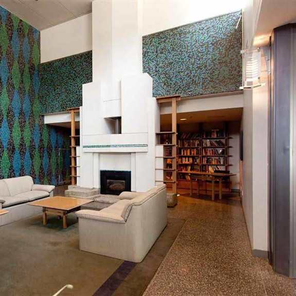 a living room with a fireplace and a bookshelf.