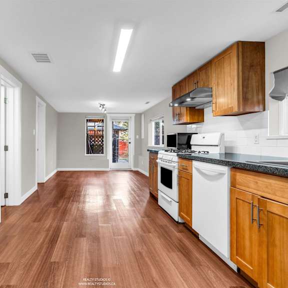 a kitchen with wooden floors and white appliances.
