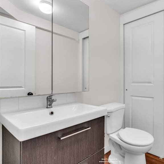 a white toilet sits next to a sink in a bathroom.