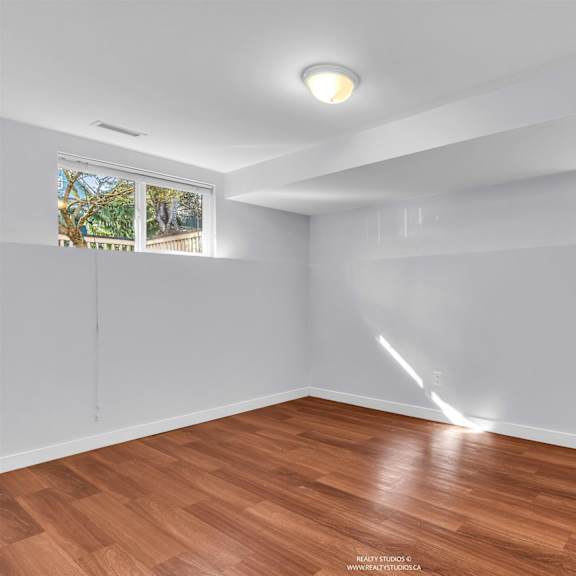 a room with wooden flooring and white walls.