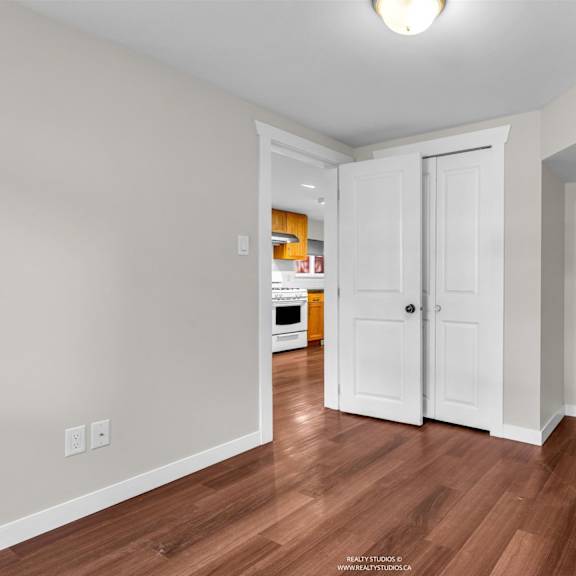 a room with a white door and a brown floor.