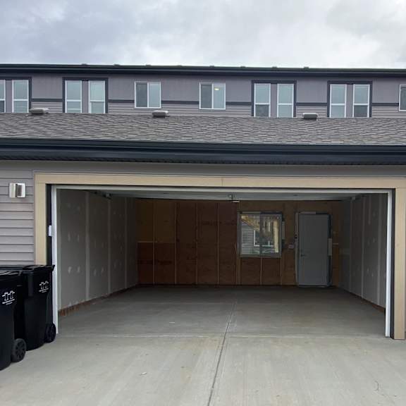 a garage with a brown door and a grey wall.