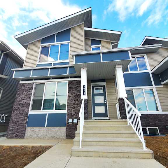 a modern house with a front porch and stairs leading to the entrance.