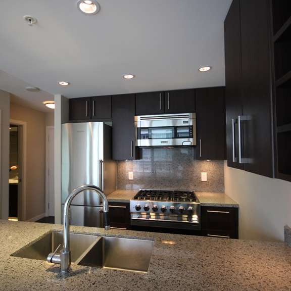 a kitchen with black cabinets and a granite counter top