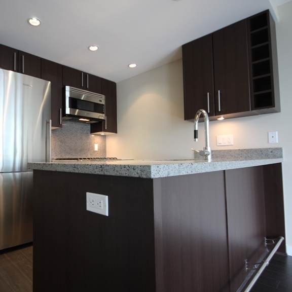 a kitchen with dark wood cabinets and granite countertops