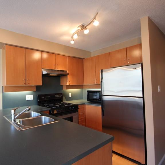 a kitchen with wooden cabinets and stainless steel appliances