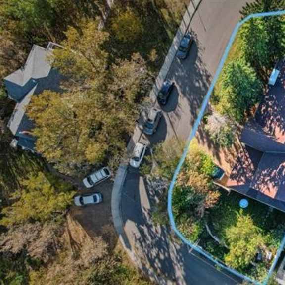a bird's eye view of a residential area with a house and a car parked in front.