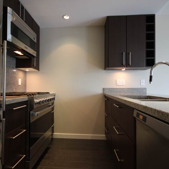a kitchen with dark cabinets and granite countertops