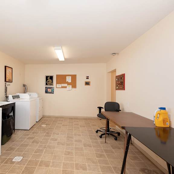 a laundry room with two washers and a table