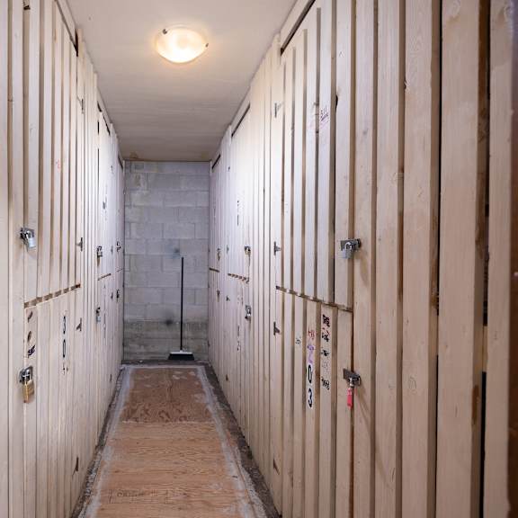 a view down a long corridor with white wooden lockers on each side of the corridor