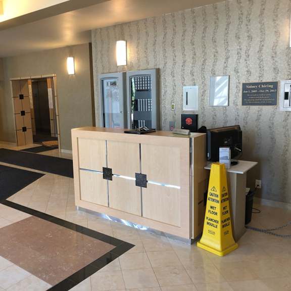 a yellow caution sign is in front of a wooden reception desk.