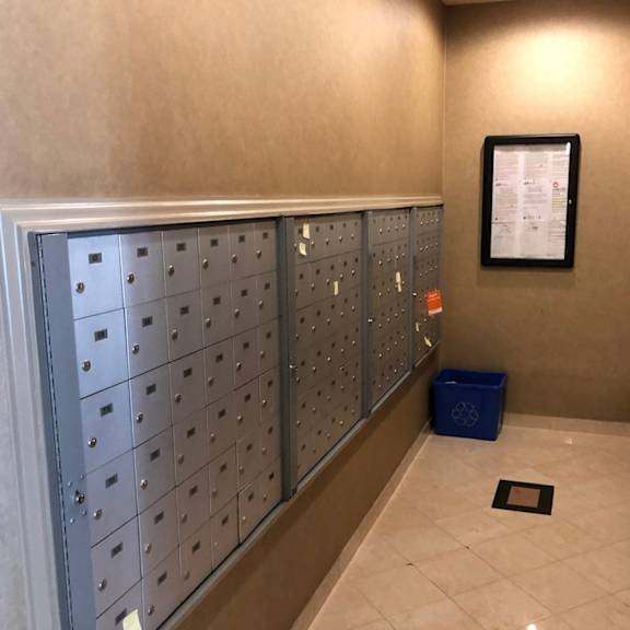 a hallway with a blue bin and a paper on the wall.