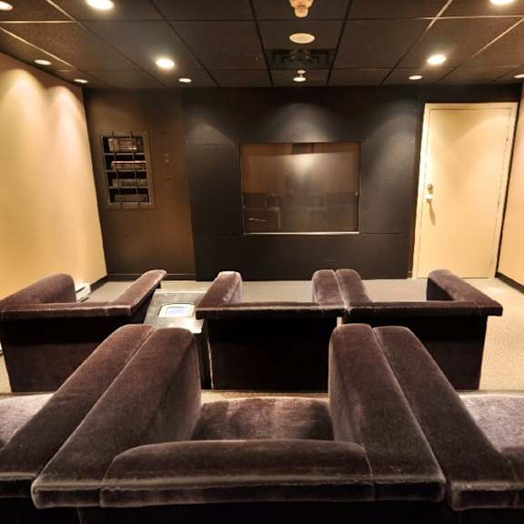 a conference room with brown chairs and a whiteboard on the wall.
